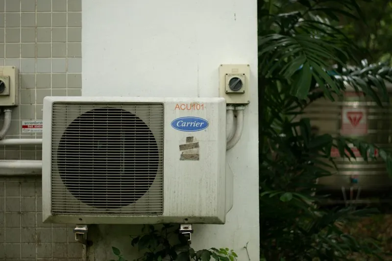 Aircon outdoor condenser unit mounted on an exterior house wall