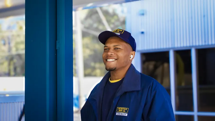 Friendly aircon technician in blue uniform and cap, smiling